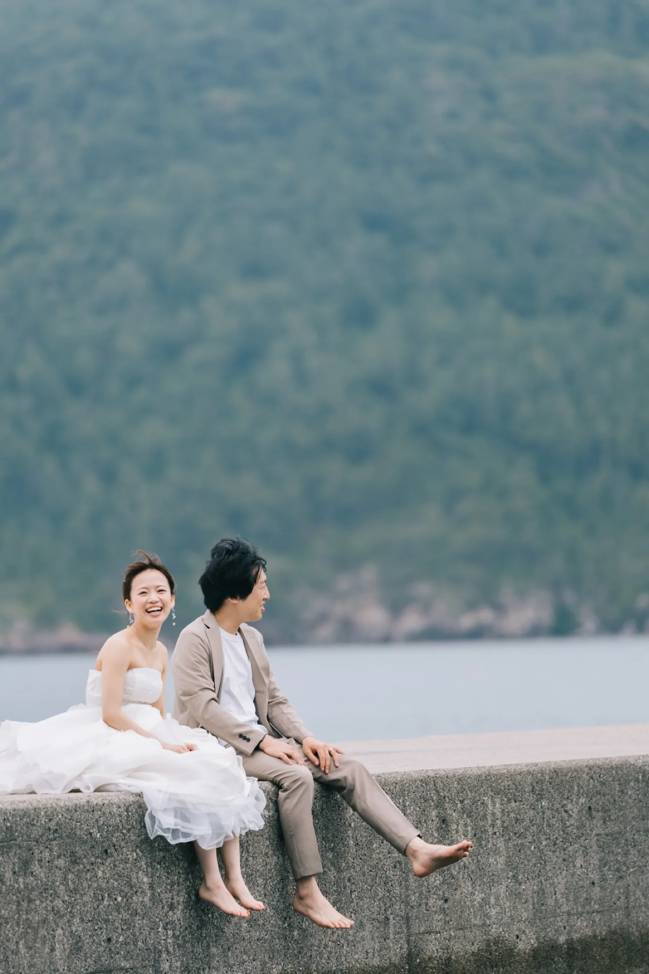 夕暮れの隠岐の海辺で歩く新郎新婦