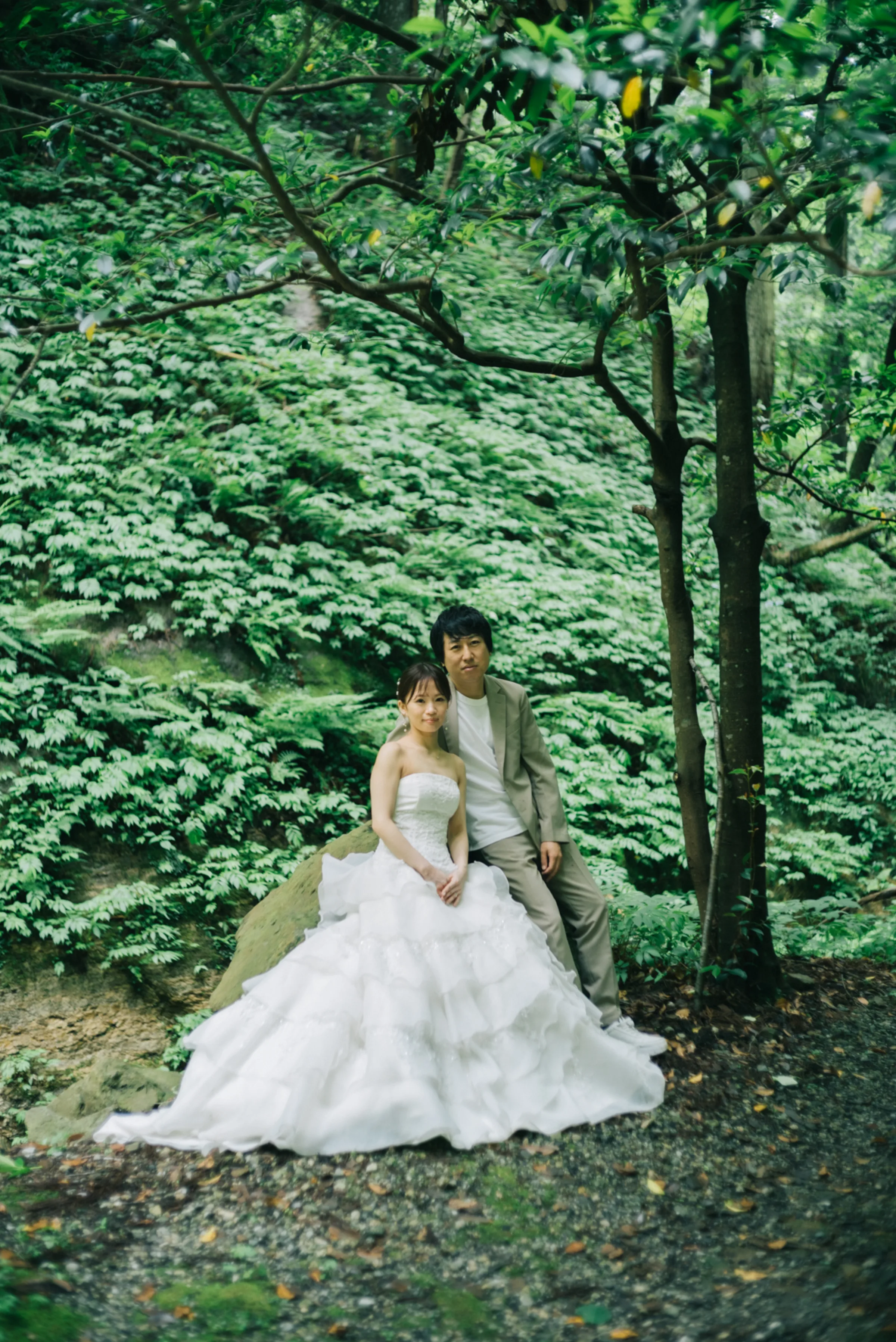 木漏れ日の森で立つ新郎新婦